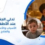 صورة توضيحية لطفل صغير يعاني من تدلي الجفن العلوي في عين واحدة، حيث يظهر الجفن النازل بوضوح، مع طبيب عيون أطفال يستخدم منظار العين لفحص الطفل وتقييم حالة تدلي الجفن عند الأطفال.